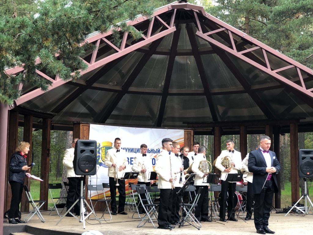 Музыканты оркестра играют на сцене в парке Сосновка