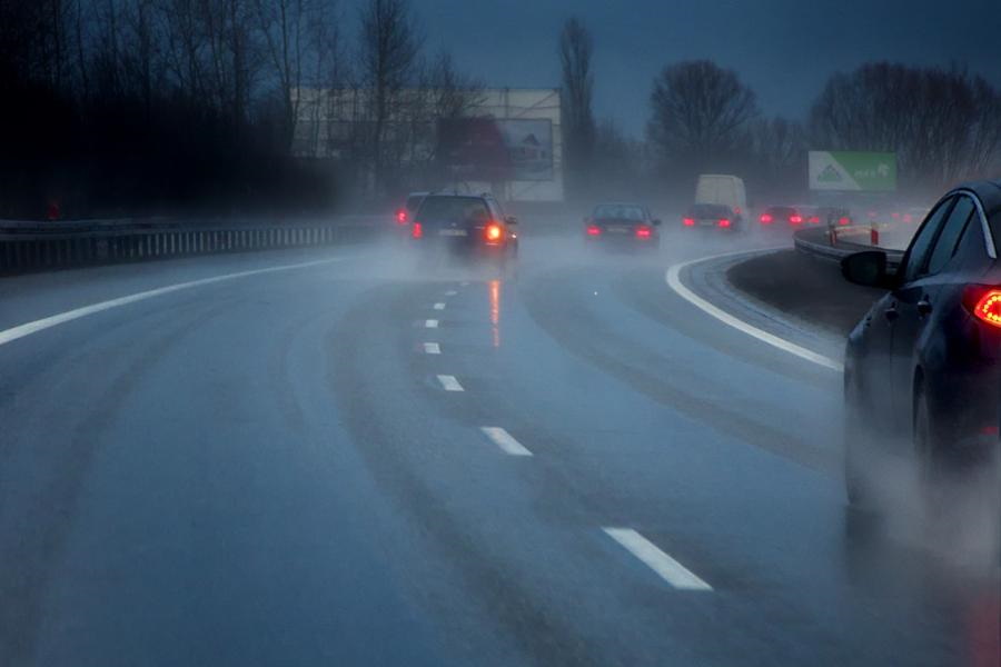 По мокрой дороге едут автомобили в темное время суток