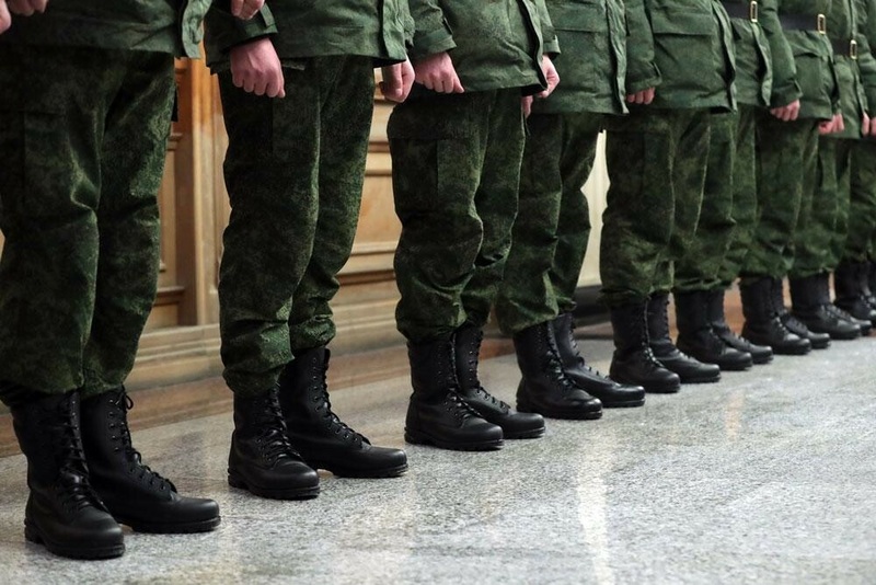 Стоят солдаты в зеленой военной форме и черных берцах.