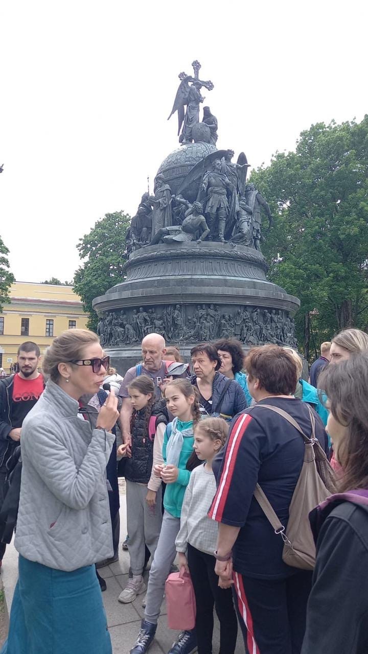 Люди на экскурсии около памятника тысячелетию Руси в Великом Новгороде