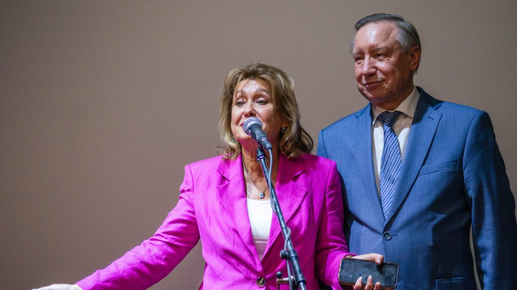 Мужчина в синем костюме, белой рубашке и синем галстуке (губернатор Санкт-Петербурга Беглов) и женщина в розовом пиджаке и белой блузке. 