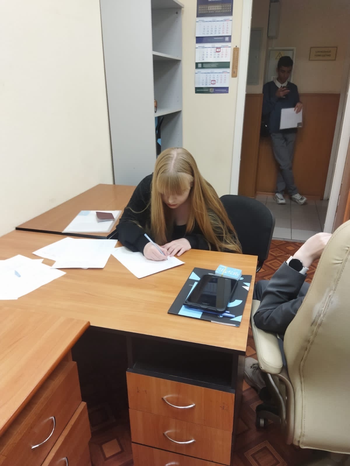 Девушка подписывает документы, сидя за столом